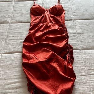 Burnt orange colored bodycon dress with rouche detail